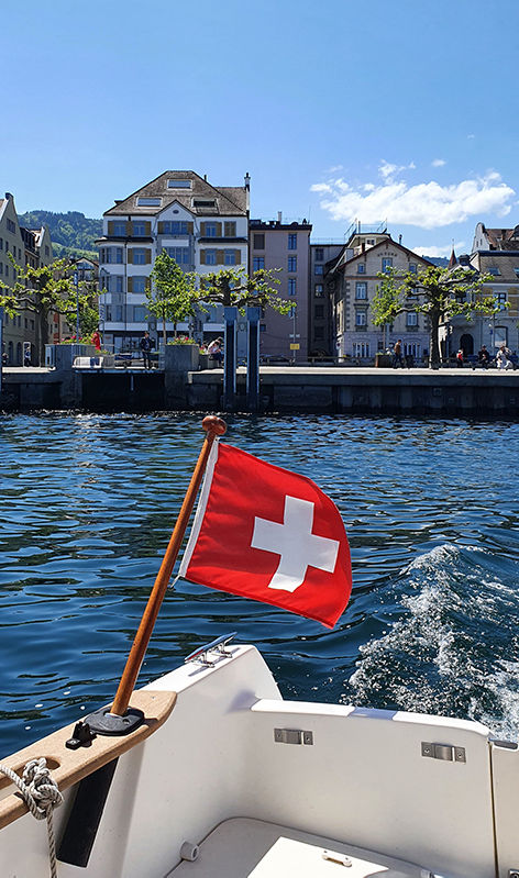 Blick vom Heck des Schulboots mit Schweizer Flagge auf den Hafen